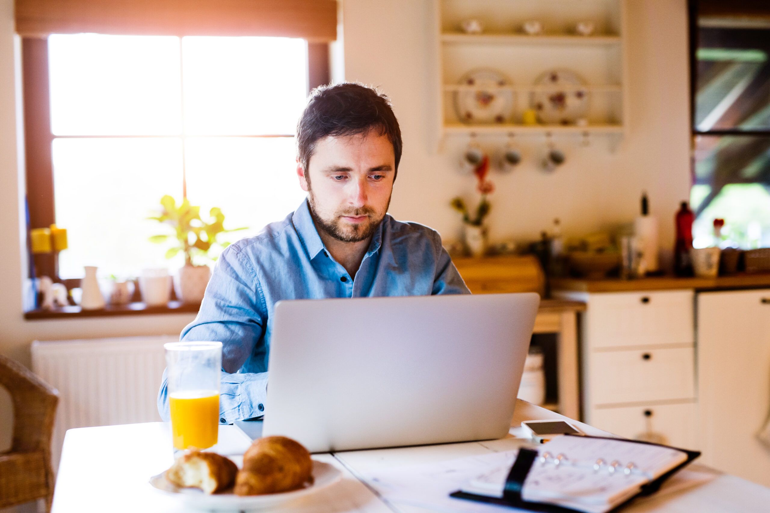 Man sitting at desk working from home with a leased laptop laptop